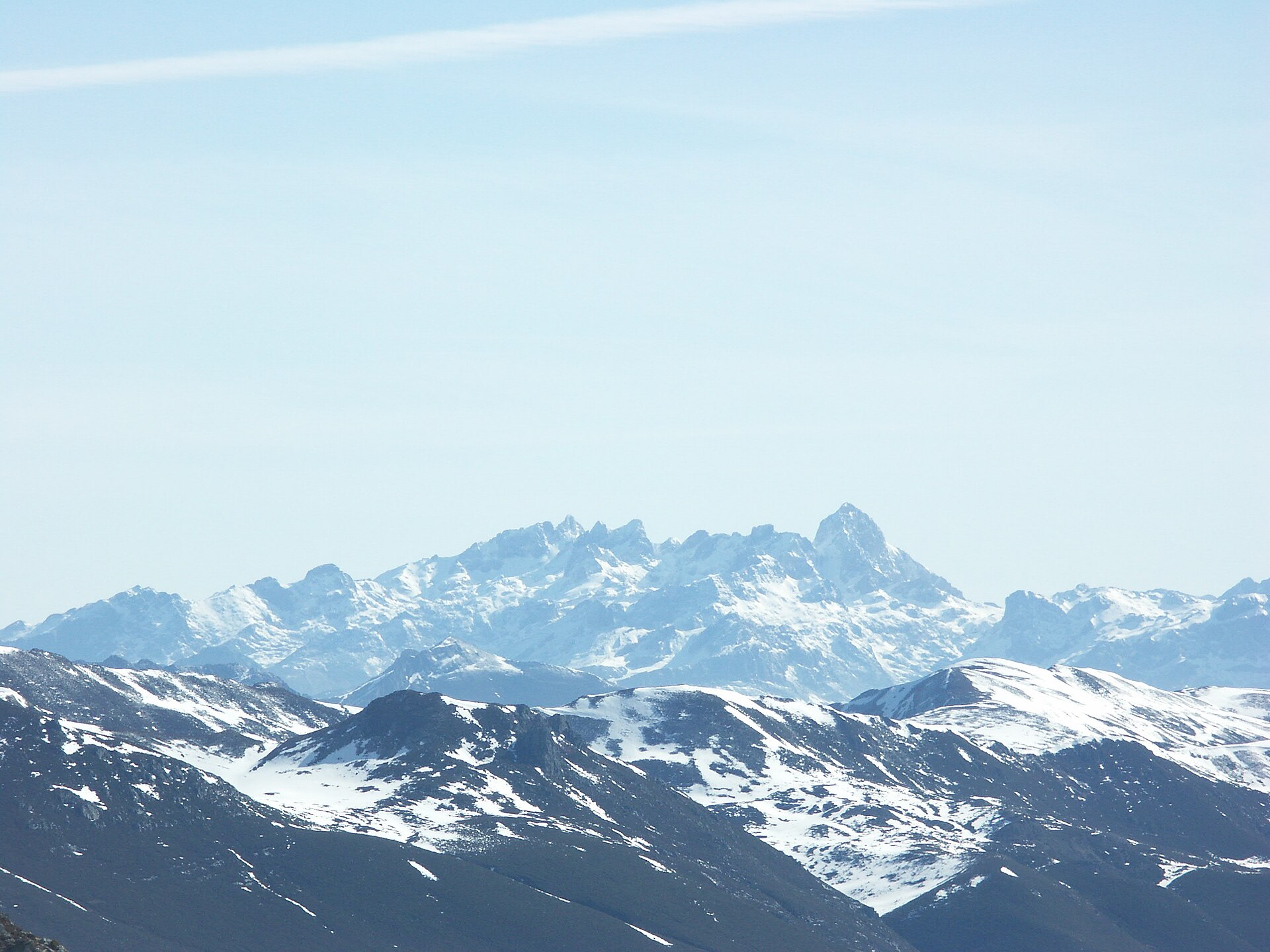 Macizo del Cornión en los Picos de Europa, cumbres nevadas al fondo y lomas en primer término.